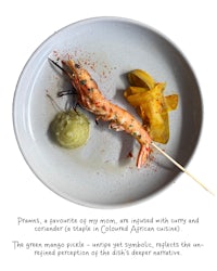 a plate with a shrimp on a skewer
