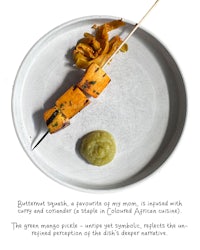 a plate with skewers and a sauce on it